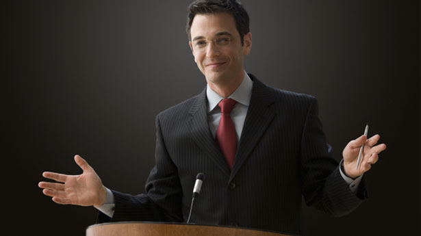 Man standing at podium via Shutterstock